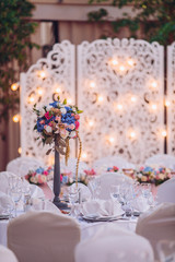 Table set for wedding or another catered event dinner. Decoration arch flowers gift box.