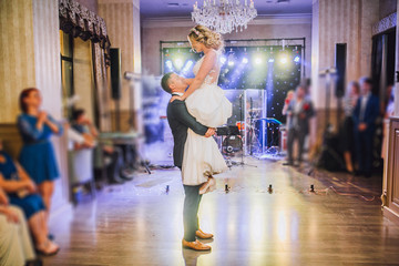 Bride and groom first dance at wedding reception with firewoks and confetti. Kissing and swing couple in love.