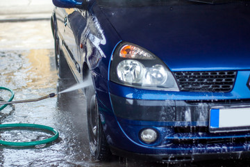 Fototapeta na wymiar Car Wash Closeup. Washing Car by High Pressure Water