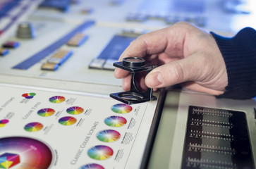 Young man in the process of offset printing and color correction