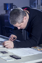 Young man in the process of offset printing and color correction