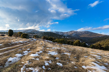 The road up the mountain. Winter snowy sunny landscape. Blue sky.