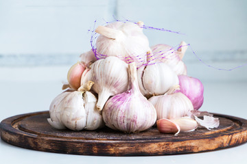 Heap of garlic bulbs on rustic wooden desk. Closeup. Copy space.