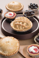 Obraz na płótnie Canvas Coconut pie and chocolate mini tart on wooden background
