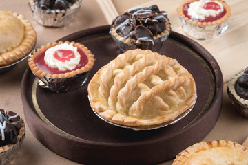 Coconut pie and chocolate mini tart on wooden background
