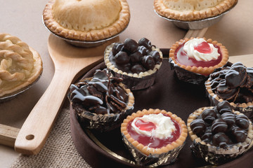 Coconut pie and chocolate mini tart on wooden background