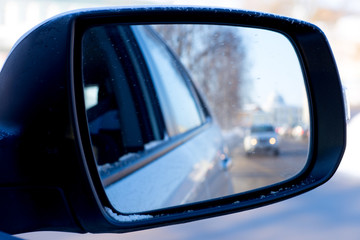black side mirror of a car reflection