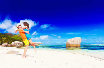 happy young couple having fun by the beach. Anse Source d'Argent, La Digue, Seychelles