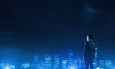 Businessman viewing night glowing city