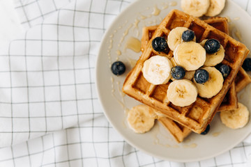 Homemade Belgian Waffles with milk and honey on table. Delicious breakfast