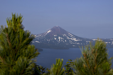 Fototapeta premium Picturesque summer volcanic landscape of Kamchatka Peninsula: view of active Ilyinsky Volcano (Ilyinskaya Sopka). Eurasia, Russia, Far East, Kurile lake, South Kamchatka Sanctuary