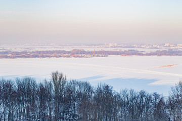 Frozen river and trees in winter evening