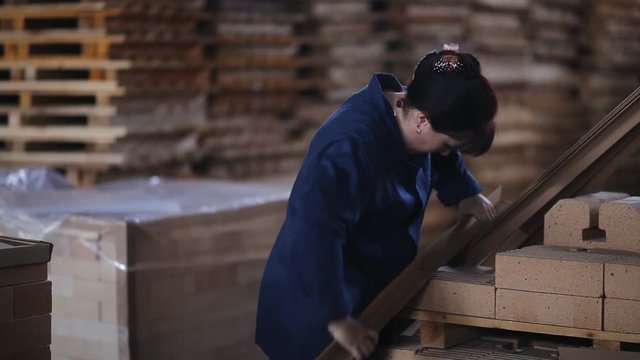 Work on the factory floor packs products. factory workers adds refractory bricks for further packaging.