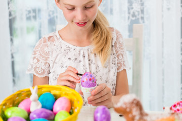 Obraz na płótnie Canvas Kleines Mädchen beim Eier färben für Ostern