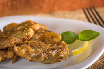 Pork brain panne on plate with lemon