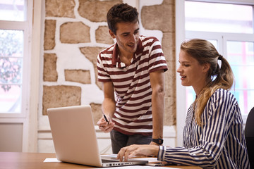 Young man looking at young businesswoman