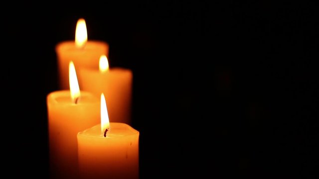 Four candles lit and extinguished. Bright light on dark background. RIP darkness template. Birthday party. Romantic evening on Valentine.