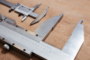 Big and small Vernier caliper on the wood table background