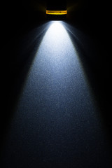 light beam, propagation of light from the LED flashlight on the metal surface painted in metallic color