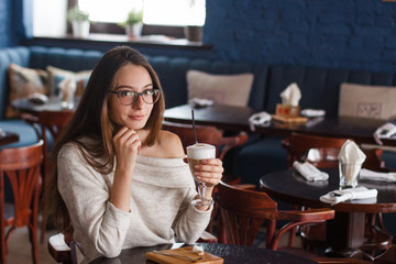 woman drinking coffee in the morning at restaurant (soft focus on the eyes)