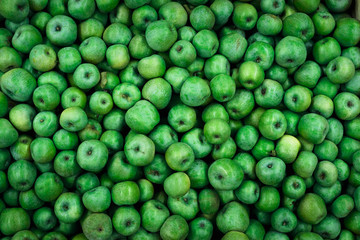 background of bright green apples on sale at the local market