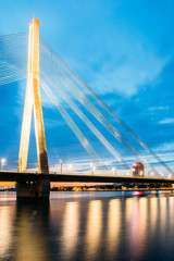 Riga Latvia. Scenic View Of Vansu Cable-Stayed Bridge In Night Illumination Over The Daugava River,