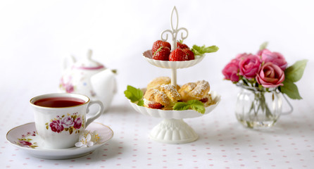 Profiterole or cream puffs cakes filled with whipped cream, strawberries in plateau
