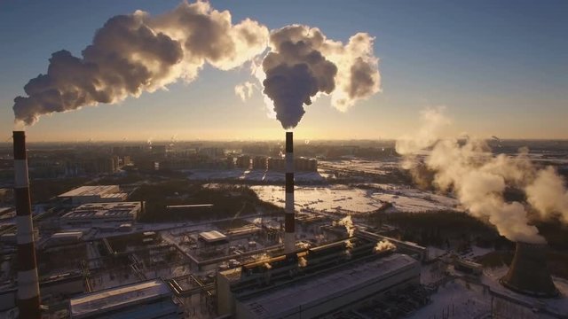 Smoking chimneys power station on sunset background in the winter. Aerial view