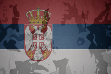 flag of serbia on the khaki texture . military concept