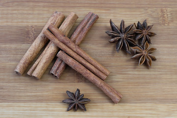Obraz na płótnie Canvas Cinnamon sticks with star anise on brown bamboo board