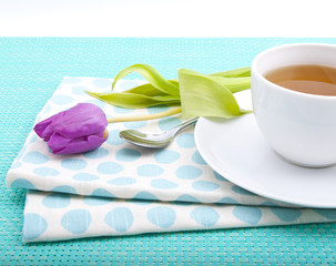 Tableware in polka dots, a cup of tea and pink tulips