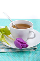 Tableware in polka dots, a cup of tea and pink tulips