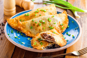 Chebureki on a plate. National Ukrainian, Russian, Turkish, Romanian and Tatar food. Meat pastry meal on a table.