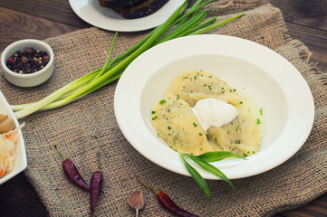 Dumplings with meat and greens. Wooden background. Top view. Close-up