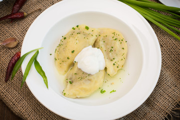 Dumplings with meat and greens. Wooden background. Top view. Close-up