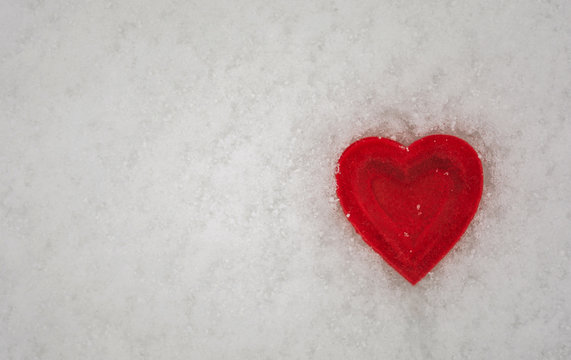 Red heart on a background of snow.  Valentine's day.