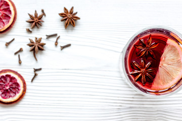 mulled wine with spices in cup wooden background top view