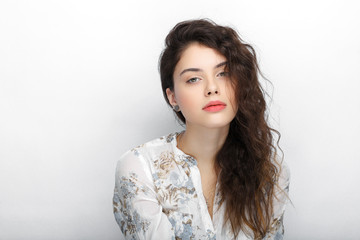 Beauty portrait of young adorable fresh looking brunette woman with long brown healthy curly hair. Emotion and facial expression lifestyle concept.