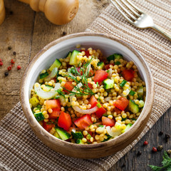 Delicious Israeli couscous Ptitim with vegetables on a table. Healthy vegetarian food for the meal. Traditional Moroccan cuisine. Top view.