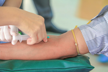 doctor injection needle syringe on arm to  collect blood 