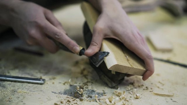 A young attractive carpenter is restoring the wood element of some furniture.