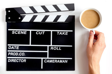 Screenwriter desktop with movie clapper board white background top view