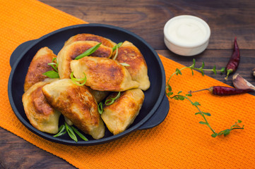 Fried dumplings in the pan. Wooden background. Top view. Close-up