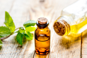 organic cosmetics with herbal extracts of mint on wooden background