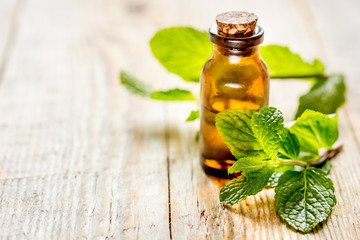 organic cosmetics with herbal extracts of mint on wooden background