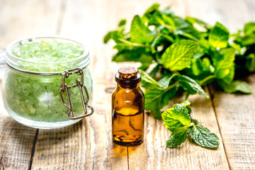 organic cosmetics with herbal extracts of mint on wooden background