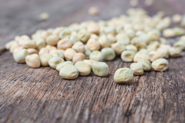 dry sugar pea seed, green nuts on the wood board background.