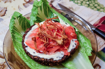 Veggie burger on lettuce leaves with tomatoes and dried onion on