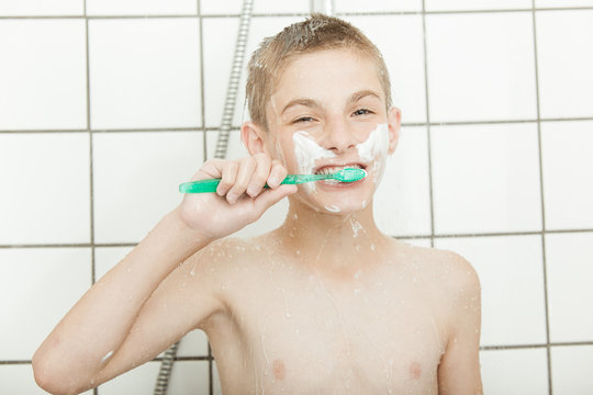Boy brushing his teeth in shower