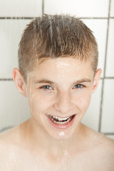 Smiling young boy in shower
